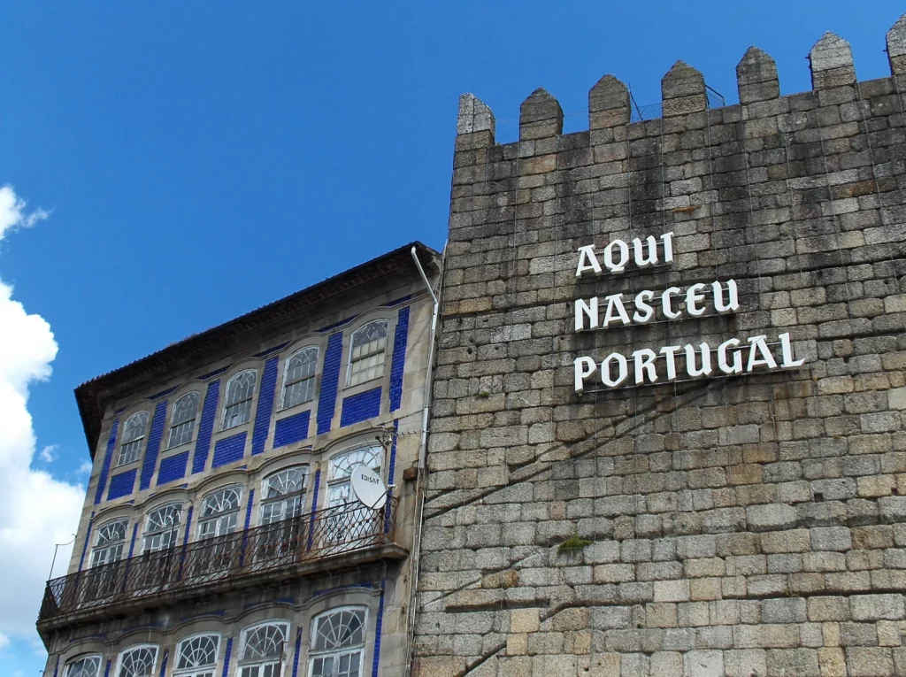 Photographie montrant la muraille défensive de Guimaraes au Portugal, avec son inscription "Aqui nasceu Portugal" signifiant "ici naquit le Portugal".