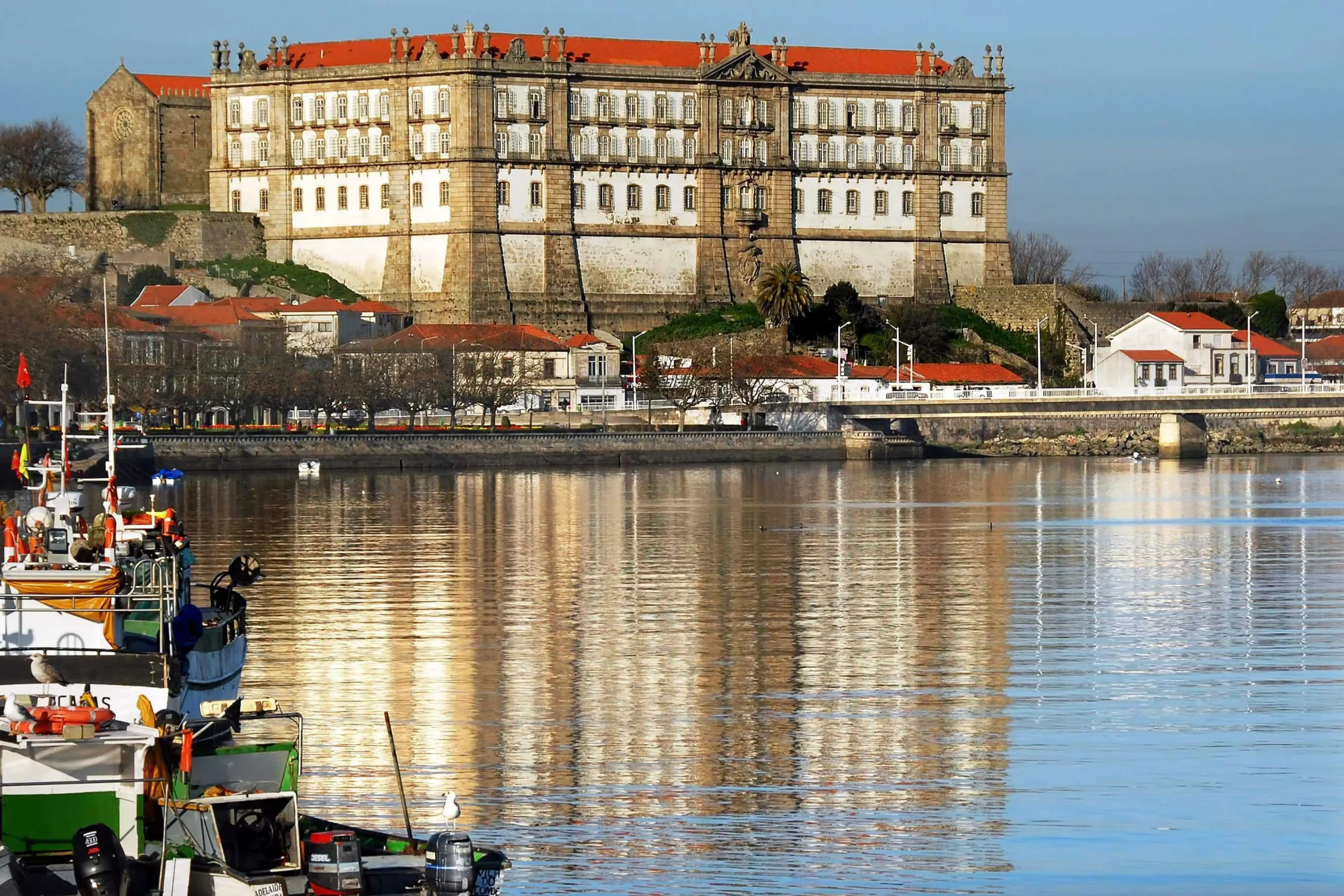 photographie montrant le monastère de Santa Clara à Vila do Conde au Portugal, se reflétant dans l'eau.