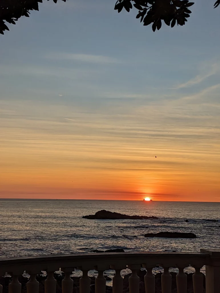 Photographie du coucher de soleil sur la mer depuis la promenade de Foz do Douro à Porto, Portugal
